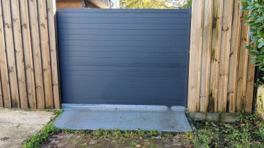 Kapı koyu gri alüminyum modern banliyö kapısı.