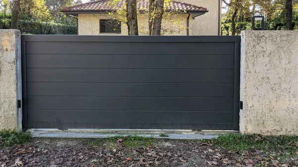 Modern evin otomatik sürgülü koyu gri kapısı