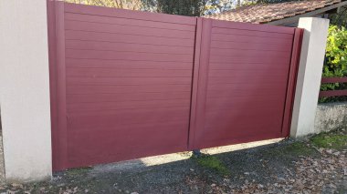 Banliyö evinin çelik kapısının büyük koyu kırmızı metal kapısı.