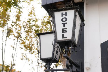 Otel tabelası, turizm şehrindeki eski bir binanın önünde eski bir lamba antika yazısına yazılmış.