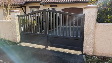 Gündüz güneşli banliyölerde bıçakları olan modern çelik kapılı alüminyum kapı.