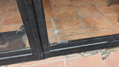 Kırık cam dükkan vitrinine zarar vermişler.