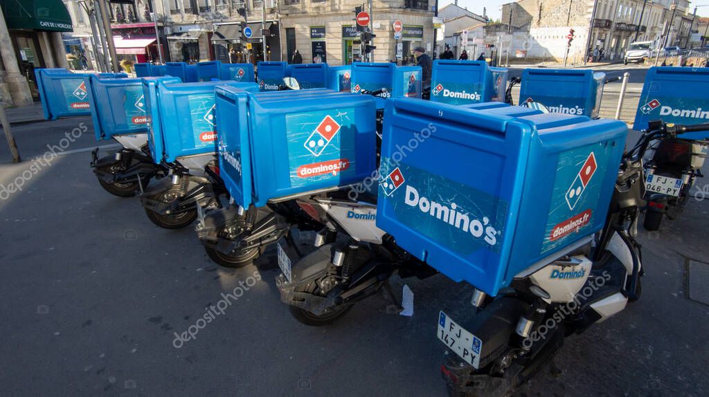 Bordeaux , Aquitaine  France - 01 18 2021 : Dominos pizza brand logo and text sign on top case motorbike delivery scooter for restaurant Domino's American pizzas fastfood