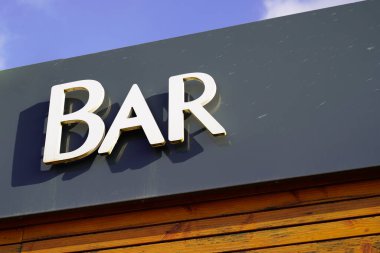 Bar üzerindeki bar tabelası bir şehir caddesi mağaza önü binası.