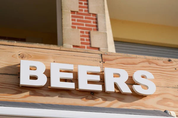 beers bar sign text on pub in city street storefront facade building