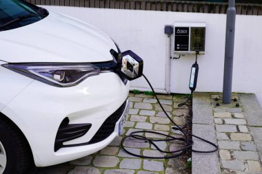 Bordeaux, Aquitaine France - 02 16 2021: Zoe Renault elektrikli araba park etmiş ve elektrik prizi de levhanın arkasında.