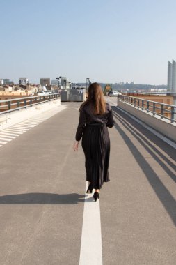 Caddede beyaz çizgide yürüyen bir kadın