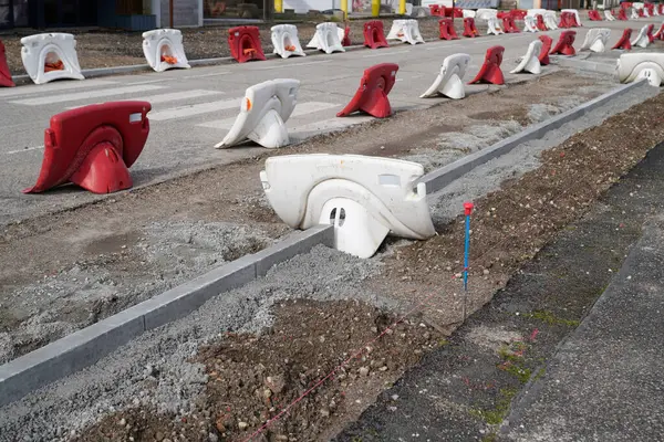 protection of work in the street by red and white mobile plastic water filled  barriers in construction site