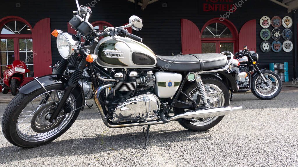 Bordeaux , Aquitaine France - 03 18 2021 : triumph bonneville t100 limited edition 110th anniversary green grey motorcycle classic retro british parked in dealership shop