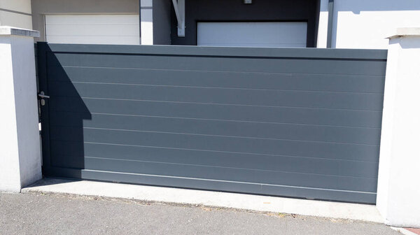 Алюминиево-серые металлические раздвижные ворота современного пригорода