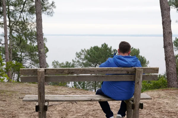 Man Achteraanzicht Terug Zitten Houten Bank Kijken Strand Water Meer — Stockfoto