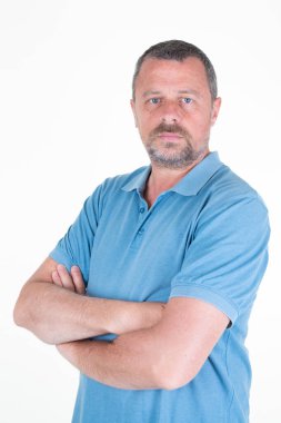 Orta yaşlı, yakışıklı, olgun erkek kolları beyaz arka planda çaprazlanmış.