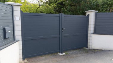 Modern, yüksek, koyu renk kapı alüminyum kapı. Banliyö evinin önündeki kapı.