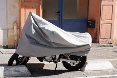 Motosiklet sokağı, gümüş koruyucu ambalajla korunuyor. Motosiklet brandası ceketini koruyor.