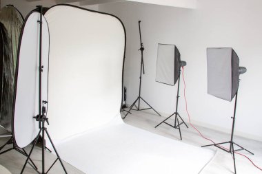 Beyaz boş fotoğraf stüdyosunun içi aydınlık. Profesyonel fotoğrafçı ekipmanlarıyla modeller çekmek için.