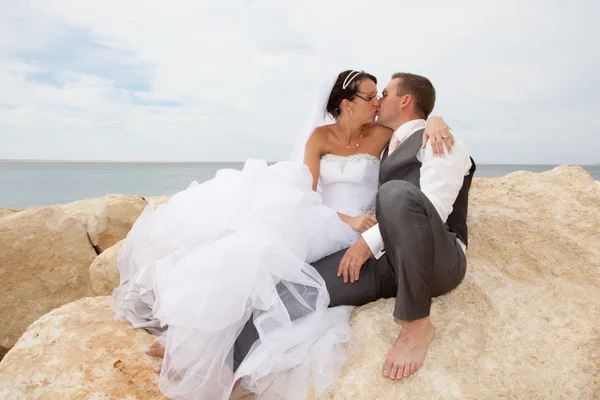 Sposa e sposo coppia sposata baciare sulla roccia — Foto Stock