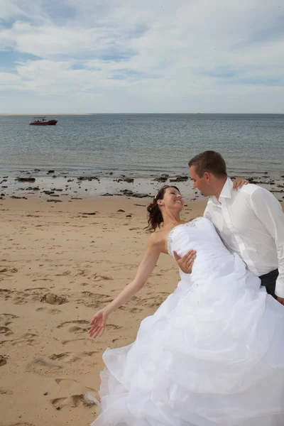 Bruden & brudgummen gift par kyssar på stranden — Stockfoto