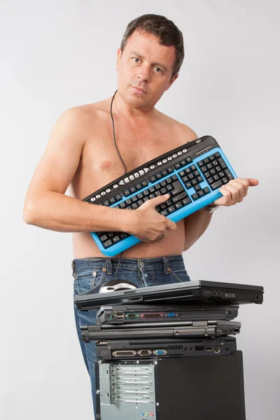 A man standing naked , hiding his body by computer keyboard — Stock Photo, Image