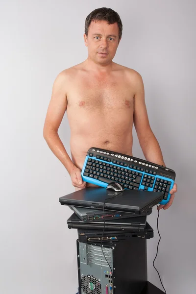 A man standing naked , hiding his body by computer keyboard — Stock Photo, Image