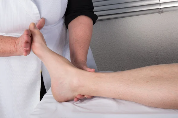 Un terapeuta che fa massaggi sul corpo dell'uomo nel salone spa — Foto Stock