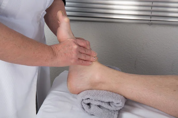 Un terapeuta haciendo masaje en el cuerpo del hombre en el salón de spa — Foto de Stock