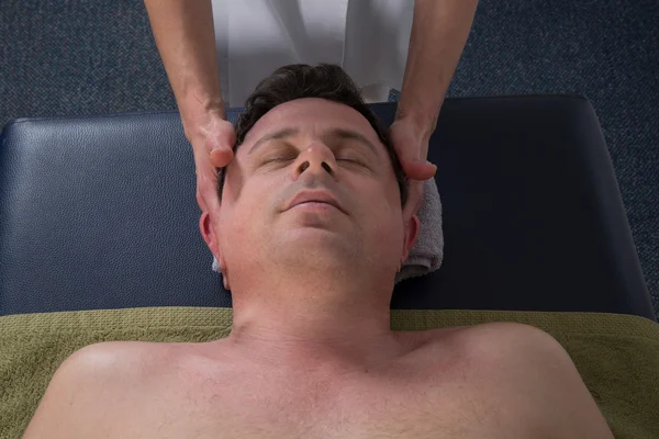 Un terapeuta haciendo masaje en el cuerpo del hombre en el salón de spa — Foto de Stock