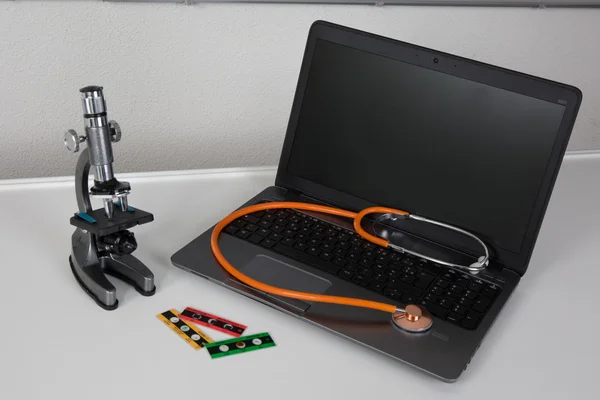 Estetoscópio laranja em um laptop — Fotografia de Stock