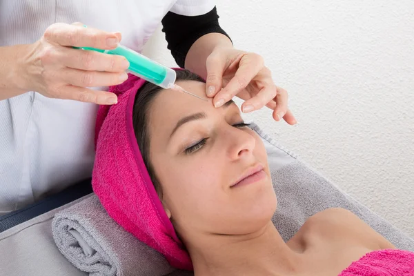 Frau bekommt Spritze ins Gesicht — Stockfoto