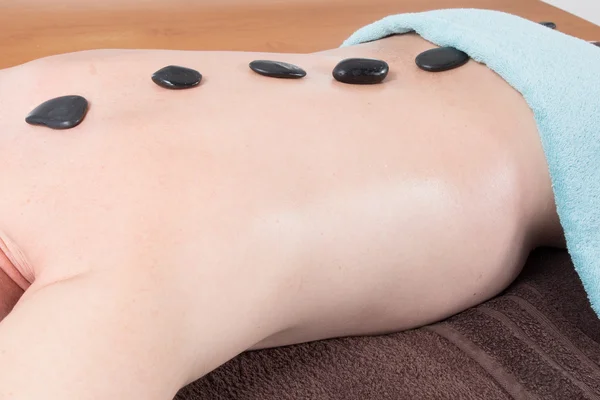 Man met stenen massage in de spa salon — Stockfoto