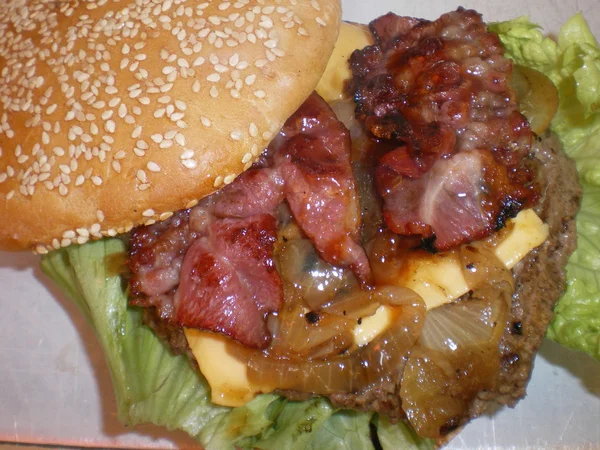 Bir hamburger marul ve soğan ile yakın çekim fotoğraf — Stok fotoğraf