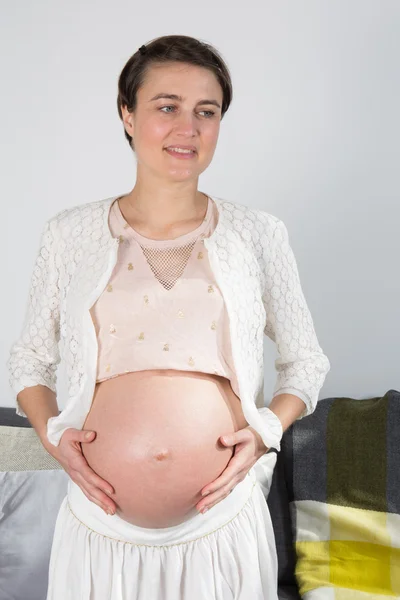 Schwangere junge Frau zu Hause — Stockfoto