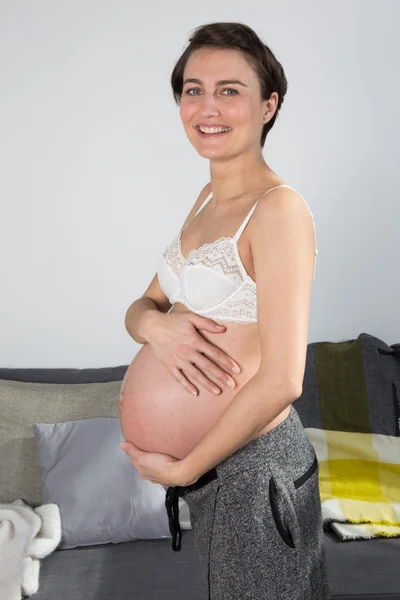 Schwangere junge Frau zu Hause — Stockfoto