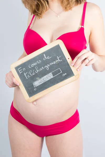 Uma mulher grávida segurando uma ardósia — Fotografia de Stock