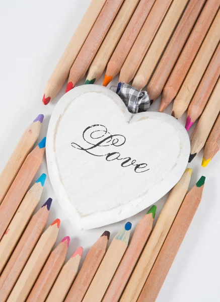 Dřevěné srdce a barevné tužky — Stock fotografie