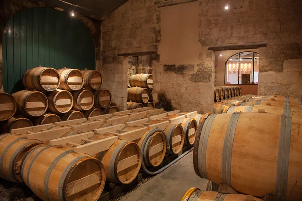 Barris de vinho empilhados na antiga adega — Fotografia de Stock