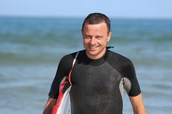 Spiaggia divertente surfista uomo a piedi con il suo body board — Foto Stock