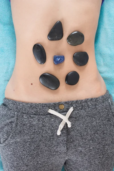 Volwassen vrouw met hot stone-massage in de spa salon — Stockfoto