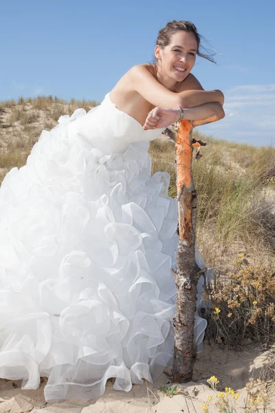 Preciosa y agradable novia en la playa bajo el cielo azul — Foto de Stock