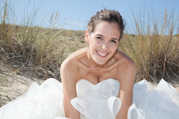 Bella e bella sposa sulla spiaggia sotto il cielo blu — Foto Stock