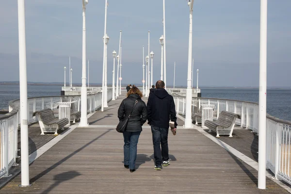 Vista posteriore di una coppia casuale che cammina lungo la costa — Foto Stock
