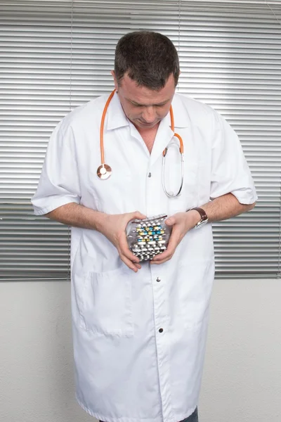 Pastillas, tabletas y medicamentos amontonan en la mano del médico , — Foto de Stock