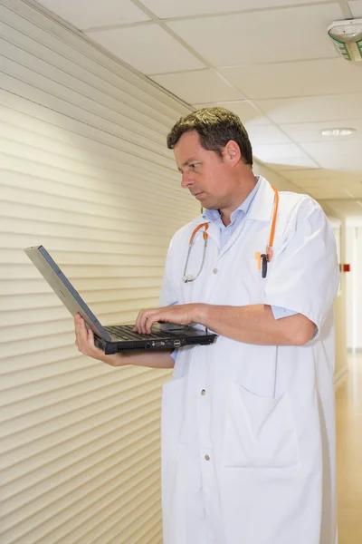 Handsome Doctor kneeling to pick up pills on the floor — Stock Photo, Image