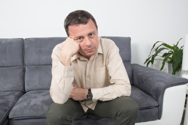 Koltukta oturan üzgün bir adam portresi