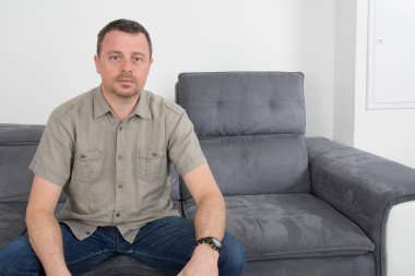 Rahat adam kanepede oturuyor.