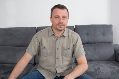 Rahat adam kanepede oturuyor.