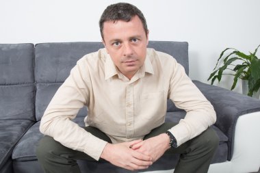 Evde koltukta oturan mutlu adam portresi