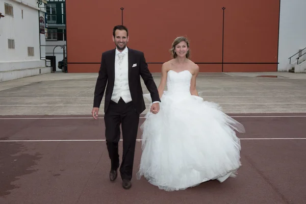 Recién casados caminando sonriendo a la cámara — Foto de Stock