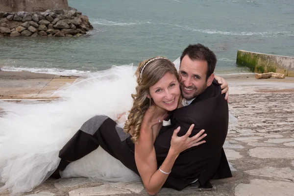 Felice sposa e lo sposo sdraiato a terra e baciare — Foto Stock