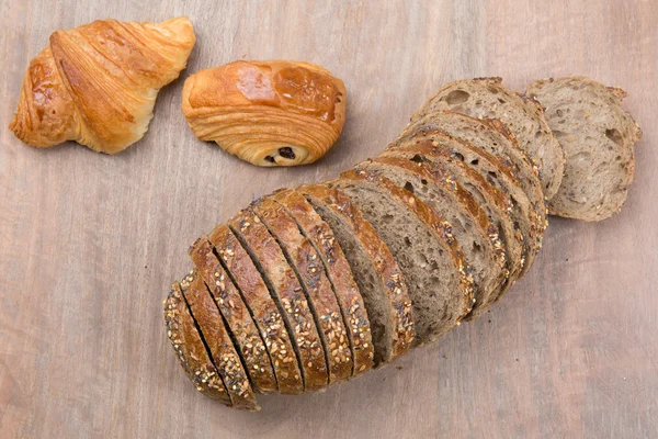 木製の茶色の背景に分離されたパンの茶色のスライス — ストック写真