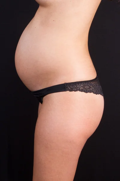 Schöner Bauch Einer Schwangeren Frau Vor Schwarzem Hintergrund — Stockfoto